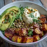 Crispy roasted sweet potato cubes paired with creamy avocado and cottage cheese in a vibrant Hot Honey Sweet Potato Bowl, drizzled with spicy-sweet honey.