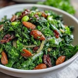 Knackiger Frühlingssalat mit Honig-Senf-Dressing, belegt mit gerösteten Mandeln und frischen Kräutern.