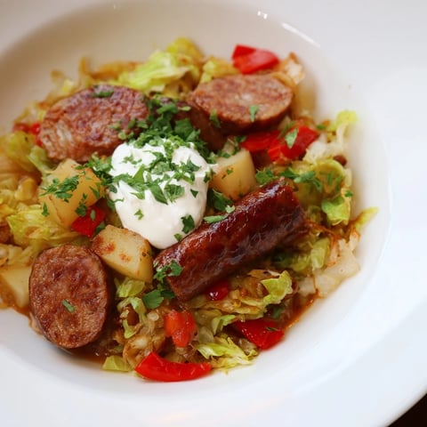 Hearty Effortless Sausage and Cabbage Stew, with tender cabbage and sausage, ready to serve with fresh parsley.