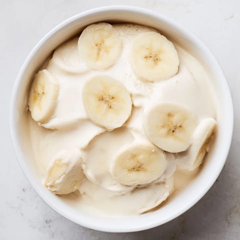 Köstliches 2-Zutaten-Bananeneis, mit gefrorenen Bananenscheiben und Milch, perfekt für eine gesunde Nascherei.