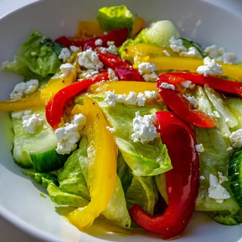 Ein köstlicher Bella Hadid Salat, hübsch angerichtet mit bunten Paprika und frischer Gurke, bereit zum Genießen.