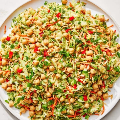 Enjoy a large bowl of fresh fiber-forward chickpea salad, loaded with crunchy cabbage and carrots.