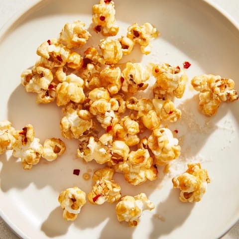 A close-up of buttery, glistening Hot Honey Butter Popcorn, savory and sweet, ready to enjoy.