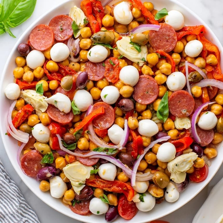 Hearty Antipasto Chickpea Salad, bursting with fresh tomatoes, olives, and a zesty Italian dressing.