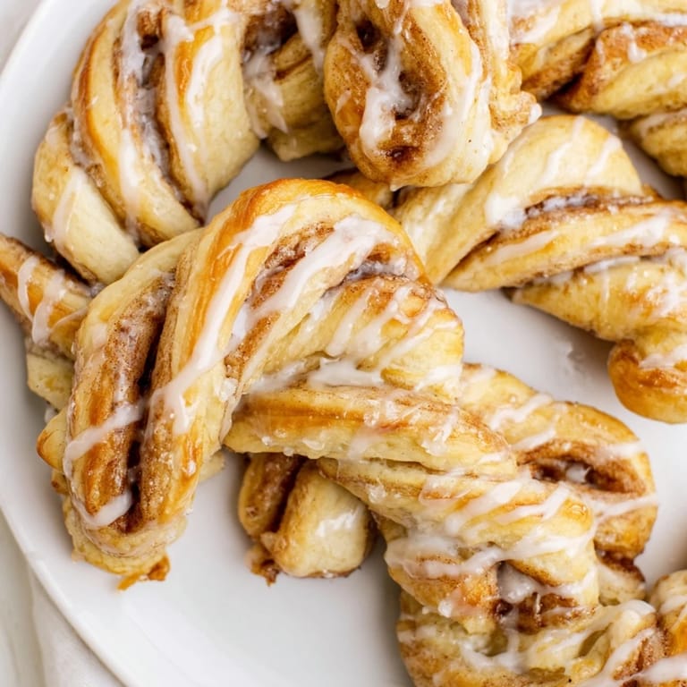 Freshly baked air-fryer cinnamon roll twists, perfectly golden and drizzled with sweet icing for a treat.